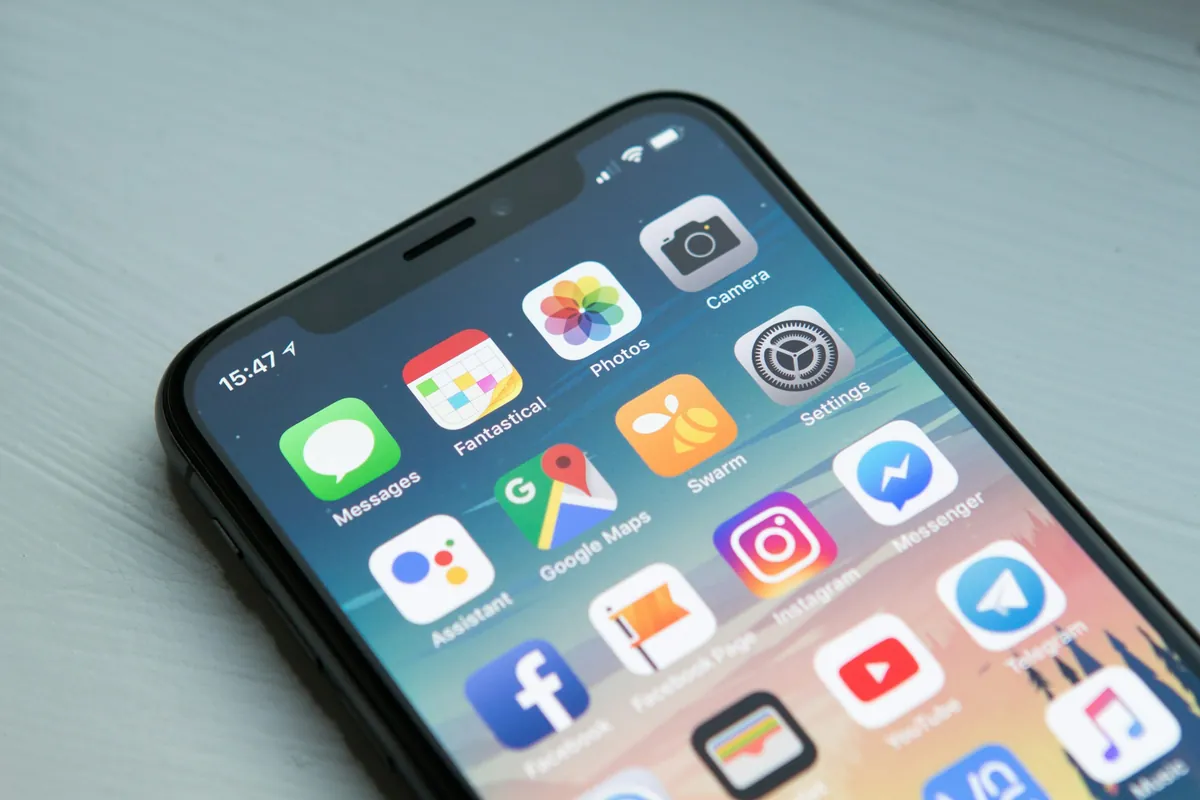 Hand holding a smartphone with travel apps open